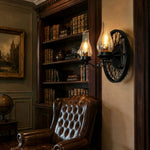 Cargar imagen en el visor de la Galería, Black two-light wagon wheel wall sconce installed in a vintage library