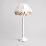 Bild in Gallery-Viewer laden, Front view of pure white ruffled fabric table lamp with sculpted metal stem