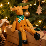 Cargar imagen en el visor de la Galería, Hand-carved wooden christmas reindeer with green scarf ornament styled on a tabletop edge