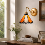 Load image into Gallery viewer, Orange stained glass wall sconce above a window console