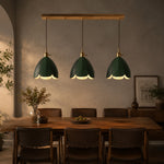 Load image into Gallery viewer, Three green leather pendant lights above a dining table