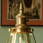 Load image into Gallery viewer, Close view of brass pendant cap and clear glass shade