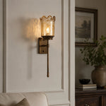 Load image into Gallery viewer, Brass amber glass wall sconce installed in a living room