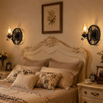 Cargar imagen en el visor de la Galería, Pair of black wagon wheel wall sconces beside a classic bedroom headboard
