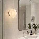 Cargar imagen en el visor de la Galería, Cream ribbed glass wall sconce near a bathroom vanity