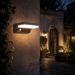 Cargar imagen en el visor de la Galería, Black outdoor wall lamp installed beside an entry at night