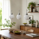 Bild in Gallery-Viewer laden, Three ribbed glass pendants above a dining table