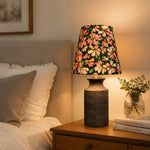 Cargar imagen en el visor de la Galería, Floral ceramic bedside lamp glowing on a nightstand in a warm bedroom