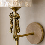 Bild in Gallery-Viewer laden, Close view of the sculpted metal bow and travertine wall plate