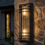 Cargar imagen en el visor de la Galería, Large bronze glass outdoor wall sconce glowing on a stone wall