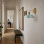 Cargar imagen en el visor de la Galería, Blue milk glass brass wall sconce in a hallway