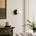Bild in Gallery-Viewer laden, Black Marble globe wall sconce beside a stone fireplace