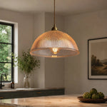 Bild in Gallery-Viewer laden, Clear ribbed glass pendant light glowing in a warm kitchen scene