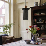 Cargar imagen en el visor de la Galería, Black woven mesh pendant light above a window-side dining table