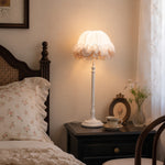 Bild in Gallery-Viewer laden, Ruffled table lamp glowing on a dark wood nightstand beside a vintage bed