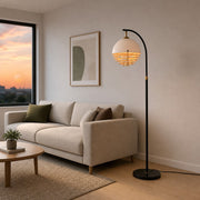 sunset floor lamp beside a neutral sofa creating warm ambient living room lighting