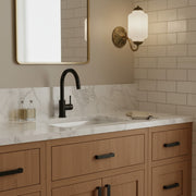 Interior design shot contrasting matte black hardware with a brass and milk glass wall sconce.