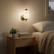 A stunning bedside reveal featuring a cream wall sconce and styled nightstand.