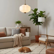 Cozy living room with a pumpkin-shaped milk glass ceiling light and a relaxed cat resting in warm ambient light