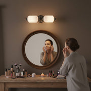 Woman enjoying evening skincare routine under soft vintage wall sconce light.