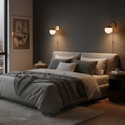 A contemporary gold wall lamp installed beside the bed in the bedroom creates a cosy atmosphere.