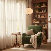 Cozy romantic reading corner with vintage lighting and soft textures.
