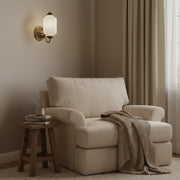 Cozy reading nook featuring a boucle armchair and the Eloise vintage milk glass wall sconce.