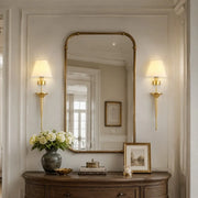 Brass fabric shade wall sconce styled in an entryway