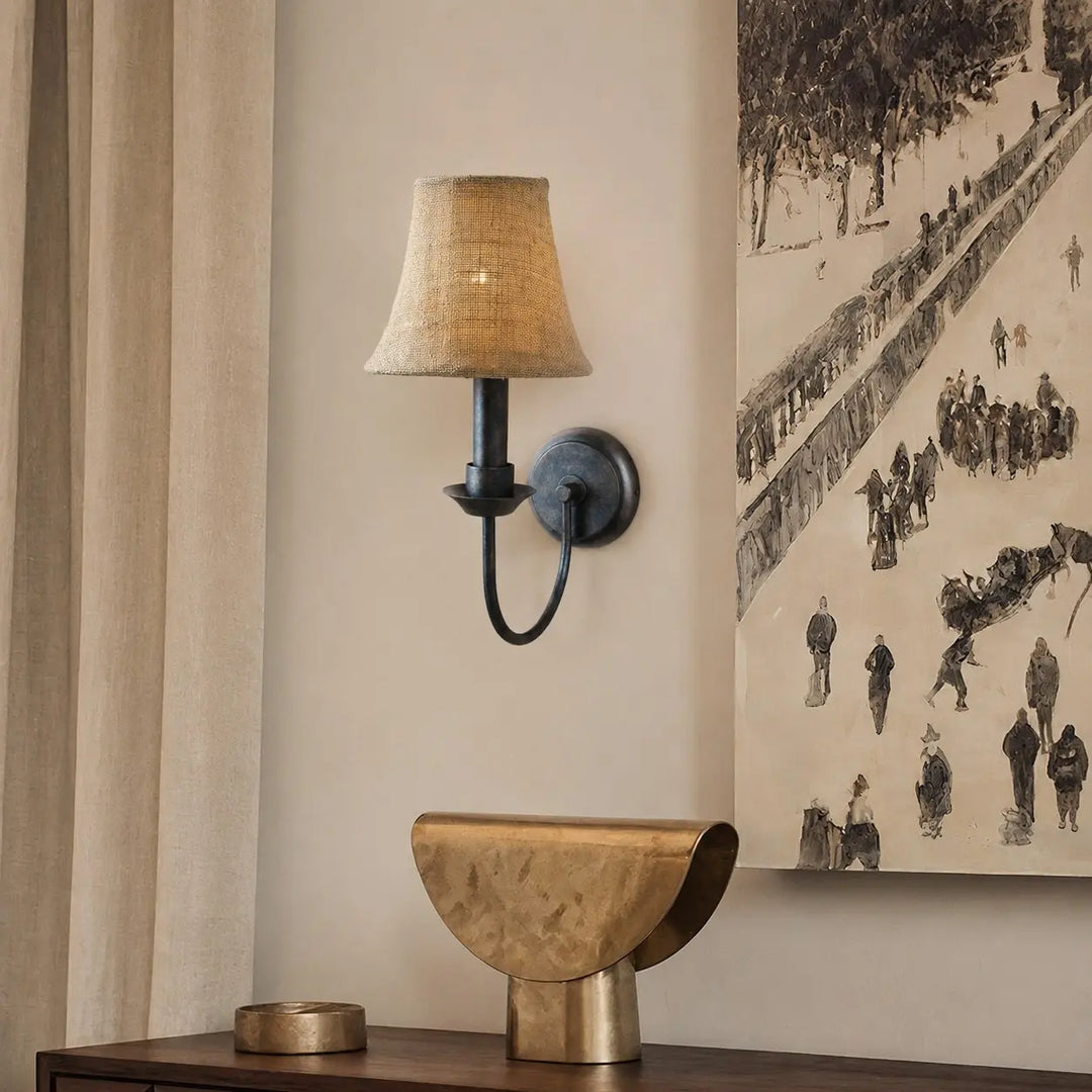 Fabric wall sconce beside framed wall art