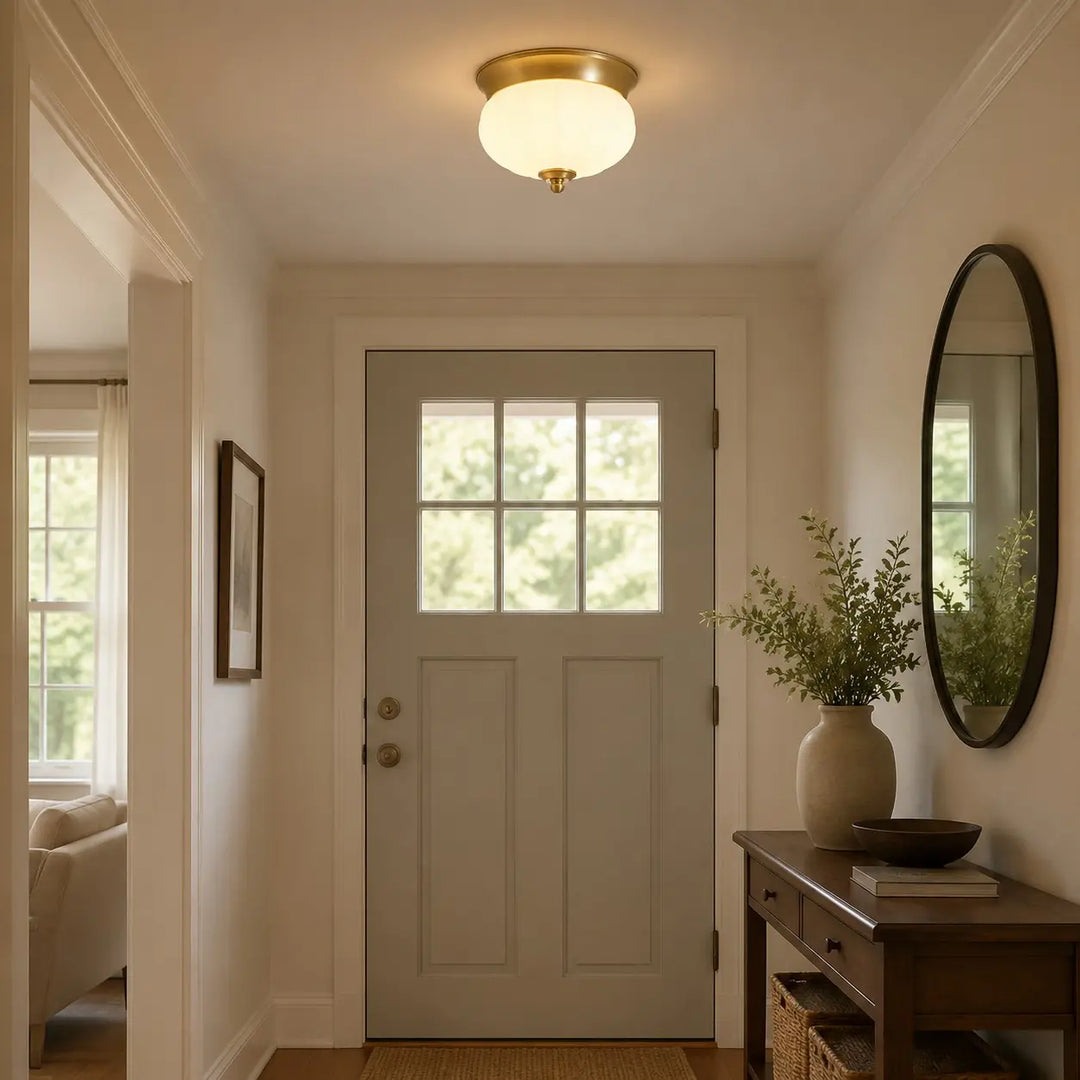 Brass and glass flush mount light in a warm entryway