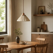 Natural linen pendant light glowing above a round dining table