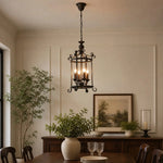 Load image into Gallery viewer, Black iron pendant installed in a bright dining room