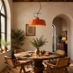 Load image into Gallery viewer, Orange metal and ceramic pendant lamp above a rustic dining table