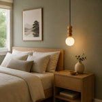 Cargar imagen en el visor de la Galería, Glowing wood bead pendant beside a calm upholstered bed