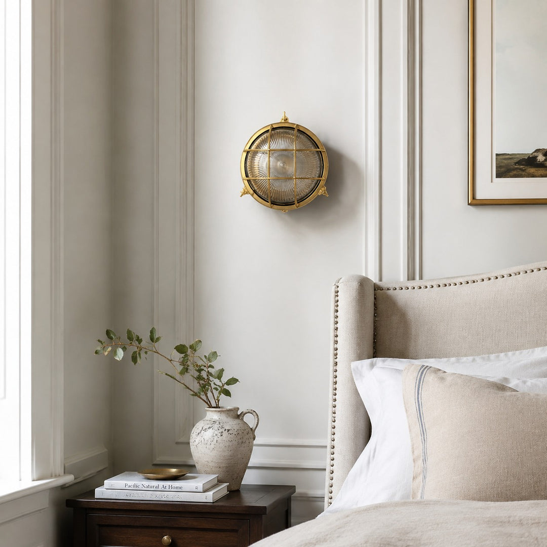Aplique de pared Ivoran Bulkhead - Luz industrial vintage de vidrio con jaula de latón para exteriores y baño