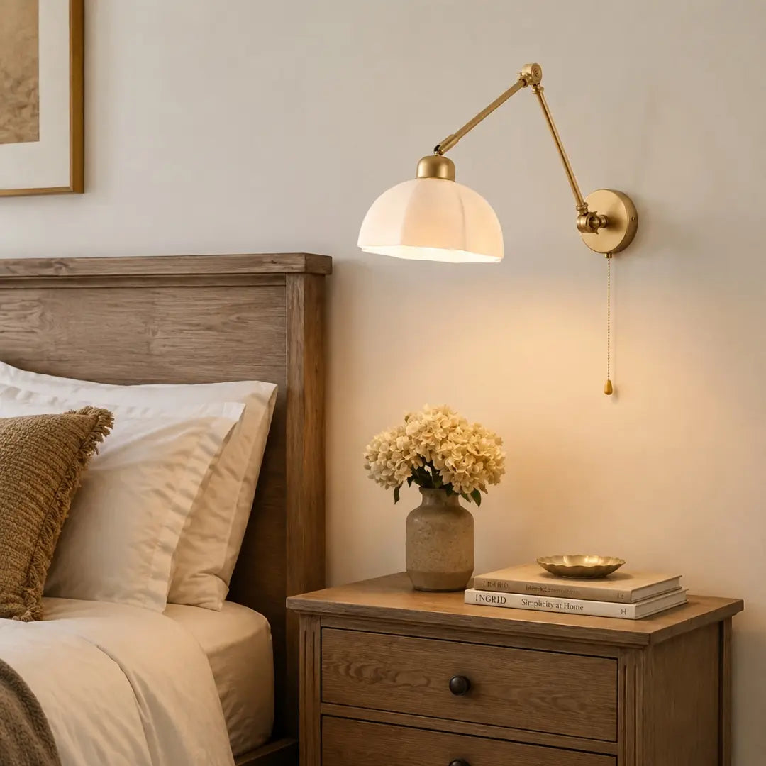 Gold wall lamp in a warm bedside setting