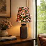 Bild in Gallery-Viewer laden, Floral ceramic table lamp illuminating a vintage console by a window