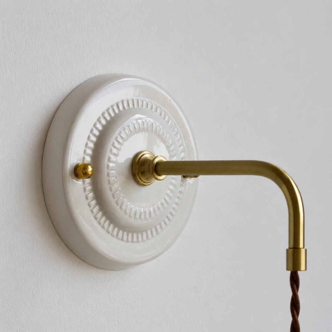 ceramic wall plate and brass arm detail