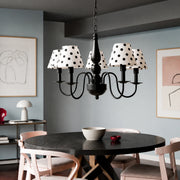 Five-light polka dot chandelier installed above a round dining table