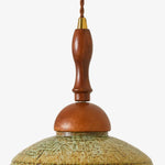 Charger l'image dans la visionneuse de galerie, Close view of the warm wood stem, metal collar and textured shallow shade on the wall sconce