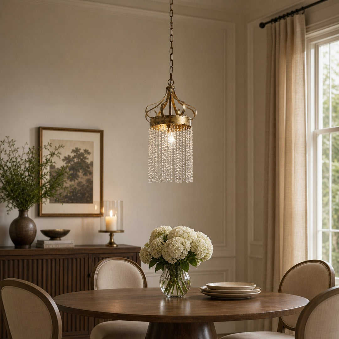 Antique brass clear crystal pendant light above a round dining table