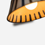 Load image into Gallery viewer, Warm light glowing through the striped ceramic shade interior