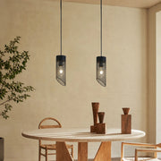 Black mesh stone pendant light installed above a round dining table