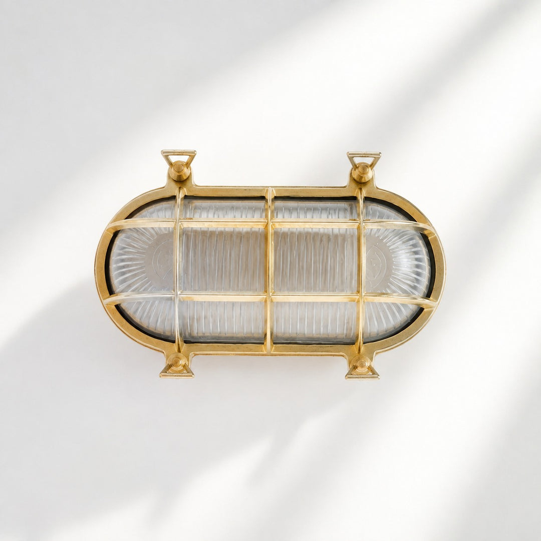 Aplique de pared Ivoran Bulkhead - Luz industrial vintage de vidrio con jaula de latón para exteriores y baño