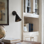 Load image into Gallery viewer, Matte black brass wall light above books and a desk corner
