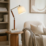 Cargar imagen en el visor de la Galería, Adjustable wooden table lamp on a side table beside an armchair