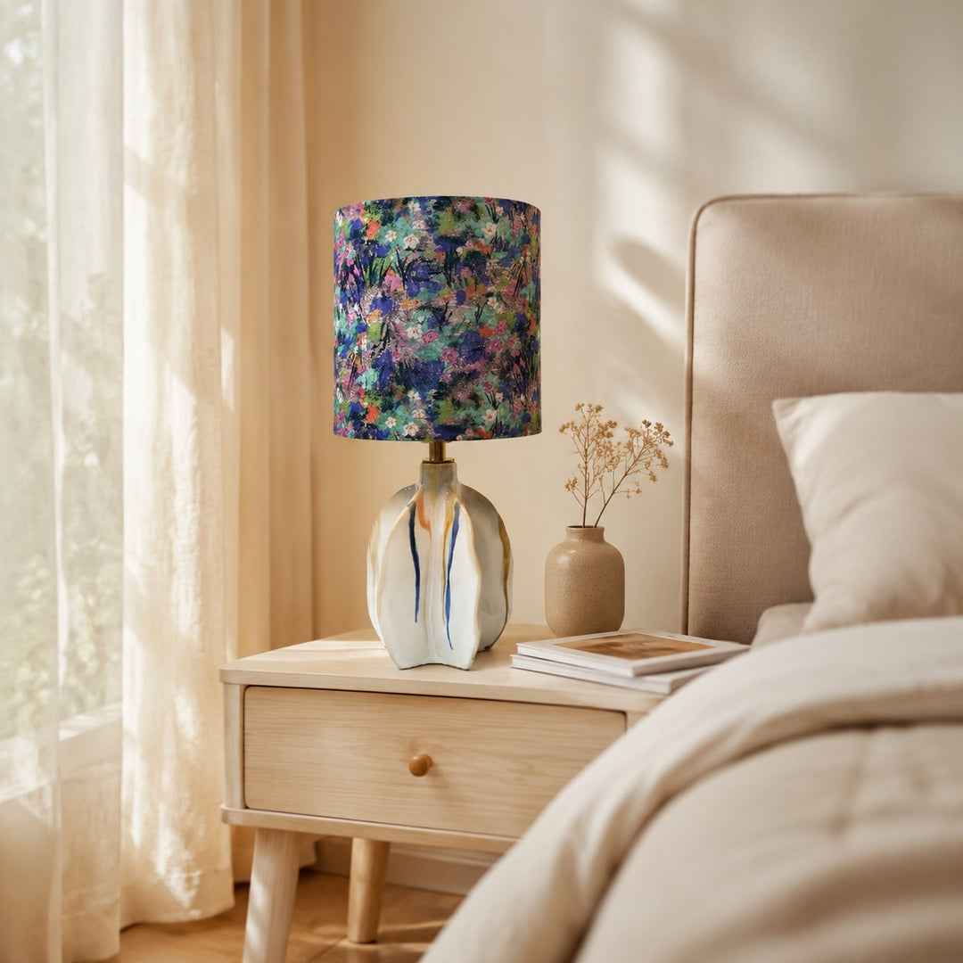 Floral fabric shade ceramic table lamp on a bedside table