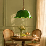 Load image into Gallery viewer, Wavy green glass pendant light over a round dining table