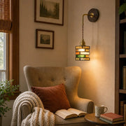 Colorful glass wall sconce beside a reading chair