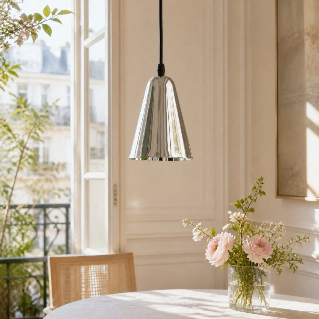 Polished chrome pendant light above a dining table